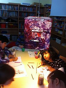 Foto von malenden SchülerInnen unter der selbstgestalteten Lampe