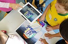 Foto von Kindern, die Trickfilme mit iPads gestalten