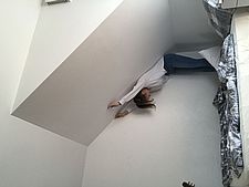 Foto einer Schülerin, die auf ihrem Bett steht und die Dachschräge mit ihrem Körper ausmisst